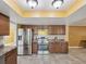 Spacious kitchen with stainless steel appliances, wooden cabinetry, and an accent tile backsplash at 4519 Swallowtail Dr, New Port Richey, FL 34653
