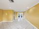 An airy, large living room is enhanced by its tile flooring, ceiling fan, and french doors at 4519 Swallowtail Dr, New Port Richey, FL 34653