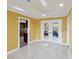 Bright living room with tile flooring, white trim, and an open doorway to the kitchen area at 4519 Swallowtail Dr, New Port Richey, FL 34653