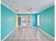 Open living room boasts tile floors, bright teal walls, a modern ceiling fan, and access to the porch at 4519 Swallowtail Dr, New Port Richey, FL 34653