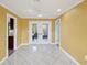 Spacious living room featuring white tile flooring, bright yellow walls, and access to the outdoor area at 4519 Swallowtail Dr, New Port Richey, FL 34653