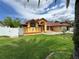 Charming single-story home with yellow facade, red accents, well-maintained lawn, and a white picket fence at 4593 Goldcoast Ave, Spring Hill, FL 34609