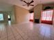 Spacious living room features tile flooring, fireplace, and bright windows with plants at 4593 Goldcoast Ave, Spring Hill, FL 34609