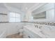 Bright bathroom featuring a marble vanity, window, and a mirror reflecting the bathtub at 4704 Shale Pl, Tampa, FL 33615