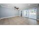 Open-concept living room with tile floors, fan, and sliding glass doors that lead out to the screened-in pool area at 4704 Shale Pl, Tampa, FL 33615