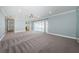 Expansive living area with neutral carpeting, natural light, and sliding doors to the outdoor area at 4704 Shale Pl, Tampa, FL 33615