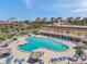An aerial view captures a spacious pool surrounded by a patio and tiki huts in this attractive community at 4900 Brittany S Dr # 805, St Petersburg, FL 33715