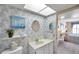 Charming bathroom with patterned wallpaper, round mirror, and skylight, adjacent to a bedroom at 4900 Brittany S Dr # 805, St Petersburg, FL 33715