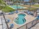 A relaxing outdoor hot tub surrounded by lounge chairs, palm trees, and a black metal fence at 4900 Brittany S Dr # 805, St Petersburg, FL 33715