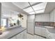 Bright kitchen with white cabinets, tiled backsplash, and a partial view of the living room at 4900 Brittany S Dr # 805, St Petersburg, FL 33715