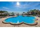 A large pool is surrounded by lush landscaping, palm trees, and lounge chairs, creating a resort-like atmosphere at 4900 Brittany S Dr # 805, St Petersburg, FL 33715