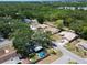 Aerial view of a home in a wooded neighborhood with a lake nearby at 5021 Roanoke Dr, Holiday, FL 34690