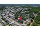 Wide aerial view of a house surrounded by trees with a lake and city in the distance at 5021 Roanoke Dr, Holiday, FL 34690