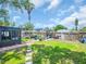 Spacious backyard with a sunroom, pergola, seating area, lush grass, and stepping stones at 5021 Roanoke Dr, Holiday, FL 34690