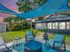 Inviting backyard patio with lounge chairs, fire pit, and shade, perfect for relaxing outdoors at 5021 Roanoke Dr, Holiday, FL 34690