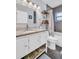 Bathroom with granite countertop, grey floors, and under-sink storage at 5021 Roanoke Dr, Holiday, FL 34690