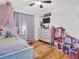 ' bedroom with wood floors, ceiling fan, and a TV at 5021 Roanoke Dr, Holiday, FL 34690