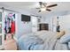Bright primary bedroom featuring a ceiling fan, TV, ensuite bathroom, and walk-in closet at 5021 Roanoke Dr, Holiday, FL 34690