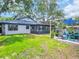 Charming home exterior featuring a sunroom, backyard patio, and mature landscaping at 5021 Roanoke Dr, Holiday, FL 34690
