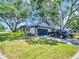 Single-story home with a blue garage door, well-maintained lawn, and a basketball hoop at 5021 Roanoke Dr, Holiday, FL 34690