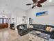 Bright living room with tile floors, a ceiling fan, and a comfortable gray sectional couch at 5021 Roanoke Dr, Holiday, FL 34690