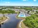 Aerial view showcasing a community pool and nearby lake surrounded by lush greenery at 6439 Cypressdale Dr # 101, Riverview, FL 33578