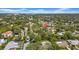 Overhead view of a neighborhood, with lush trees, single-Gathering homes, and city skyline at 650 Arbor Ln, Largo, FL 33770