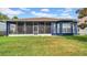 View of the blue house and screened in lanai from the backyard at 650 Arbor Ln, Largo, FL 33770