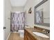 Bathroom featuring granite vanity top, shower with a patterned curtain and tile flooring at 650 Arbor Ln, Largo, FL 33770