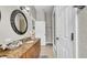 Bathroom with granite countertop, oval framed mirror and doorway into the water closet and shower at 650 Arbor Ln, Largo, FL 33770
