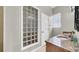 Bathroom featuring a glass block window and wall and a granite-topped vanity with double sinks at 650 Arbor Ln, Largo, FL 33770