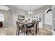 Well-lit dining area with a rustic wood table, chandelier, and a charming display cabinet at 650 Arbor Ln, Largo, FL 33770
