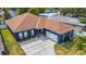 Charming single-story home featuring a two-car garage, dark blue facade, and well-maintained landscaping at 650 Arbor Ln, Largo, FL 33770