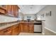Stylish kitchen showcasing granite counters, stainless steel dishwasher, and wood cabinets at 650 Arbor Ln, Largo, FL 33770