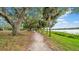 Peaceful park trail lined with trees leads to a tranquil lake view at 650 Arbor Ln, Largo, FL 33770