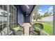 A shaded screened in patio with wicker furniture overlooks the green lawn at 650 Arbor Ln, Largo, FL 33770