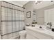 Well-lit bathroom featuring a shower with a striped curtain and a clean, white vanity at 6526 Summer Cove Dr, Riverview, FL 33578