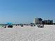 Picturesque beach scene with blue skies, white sand, and a condominium building in the background at 6700 Sunset Way # 206, St Pete Beach, FL 33706