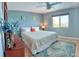Coastal bedroom features light blue walls, a ceiling fan, dresser, a view, and blue accents at 6700 Sunset Way # 206, St Pete Beach, FL 33706