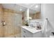 Bathroom featuring a tiled shower with glass, a white vanity, and a decorative mirror at 701 S Madison Ave # 414, Clearwater, FL 33756