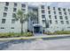 Exterior view of condo building 'South' entrance, featuring landscaping with palms and other plants at 701 S Madison Ave # 414, Clearwater, FL 33756