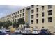 Multi-story building featuring covered parking, palm trees, and many windows at 701 S Madison Ave # 414, Clearwater, FL 33756