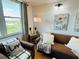 Cozy living room featuring a comfortable brown sofa, throw pillows, and natural light from a nearby window at 701 S Madison Ave # 414, Clearwater, FL 33756