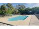 A serene community pool surrounded by mature trees and a secure fence at 701 S Madison Ave # 414, Clearwater, FL 33756
