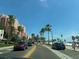 Street view showcasing nearby condo building and palm trees under a blue sky at 701 S Madison Ave # 414, Clearwater, FL 33756