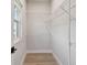 Bright walk-in closet with wood-look flooring, white walls, and wire shelving at 7236 Sutton Ln, Sarasota, FL 34240