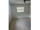 Bright bedroom with tiled floors, neutral walls, and a large window with blinds at 7401 N Albany Ave, Tampa, FL 33604