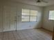 Bright bedroom featuring tile flooring, neutral walls, and ample natural light from two windows at 7401 N Albany Ave, Tampa, FL 33604