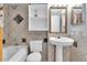 Bathroom with updated tiles, pedestal sink, and bathtub with shower at 7505 Pitch Pine Cir # 122, Tampa, FL 33617