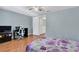 Bright bedroom with light walls, ceiling fan, wood floor, and door to the other room at 7505 Pitch Pine Cir # 122, Tampa, FL 33617
